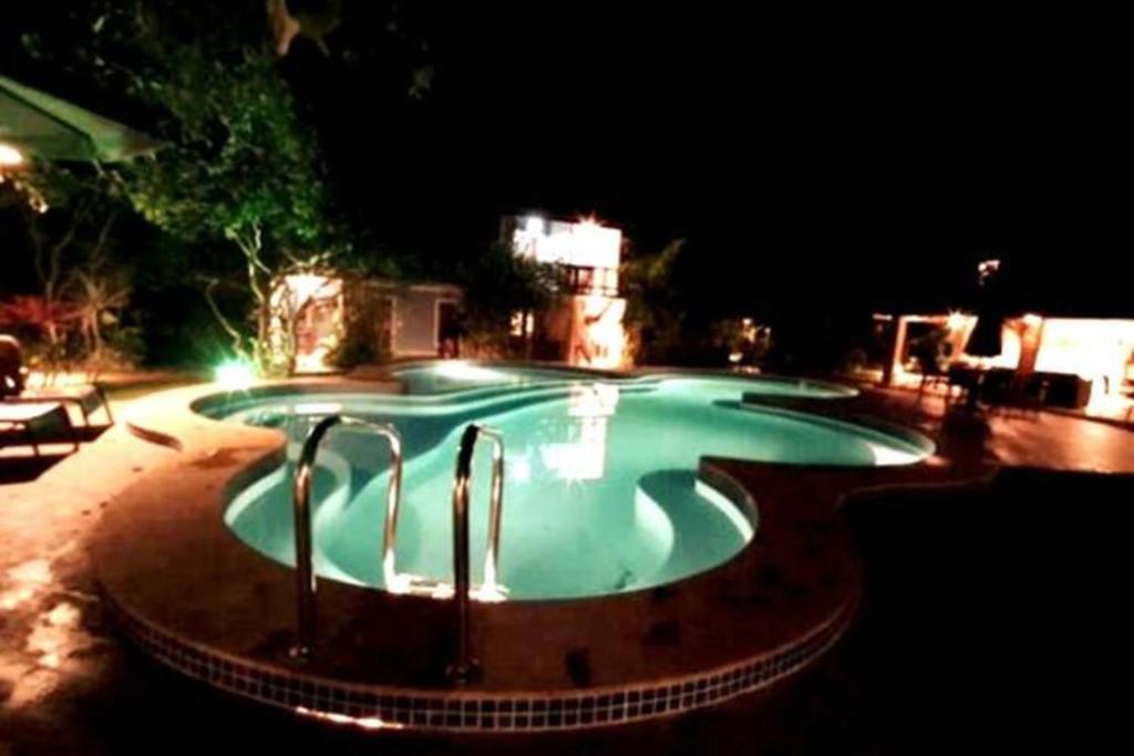 因巴塞Imbassai - Casa Alto Padrão completa - Condominio Fechado - A1B1的夜间大型游泳池,灯光照亮