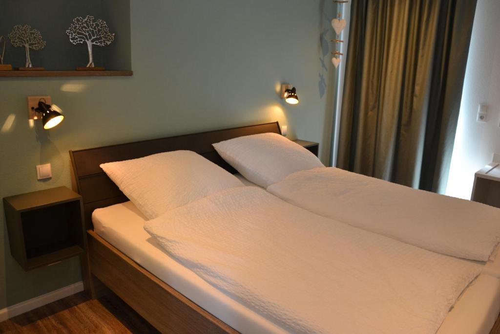 LastrupGasthof Zumdohme的卧室内的一张带白色床单和枕头的床