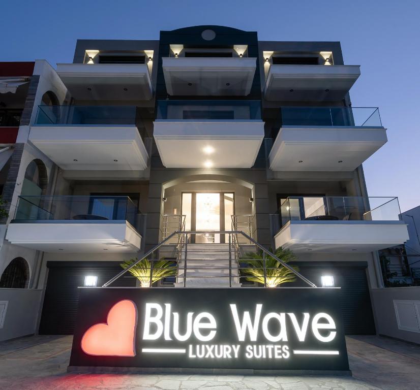 伊拉克里萨Blue Wave Luxury Suites的前方的一栋带蓝波豪华套房标志的建筑