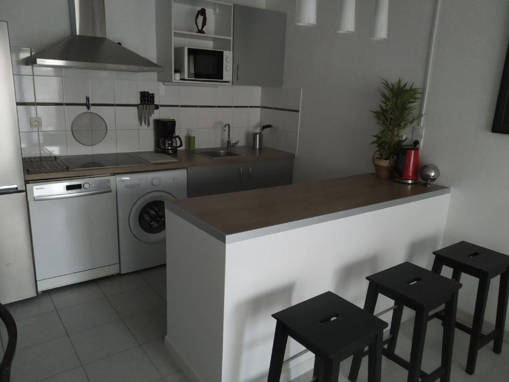 普瓦捷A Poitiers, 2 chambres, très bel appartement de 65 m2的厨房配有水槽和带凳子的台面