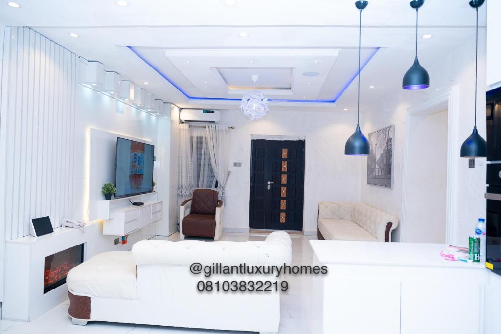 贝宁城Gillant Luxury Homes的配有白色家具和电视的客厅