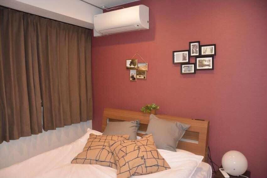 东京AN HOTEL的一间卧室配有一张红色墙壁的床