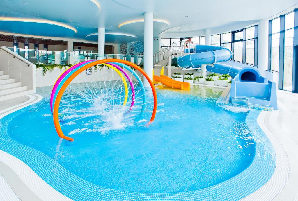 科沃布热格Aqua Resort Apartments - Pool & Sauna, Aqua Park的大楼内一个带水滑梯的大型游泳池
