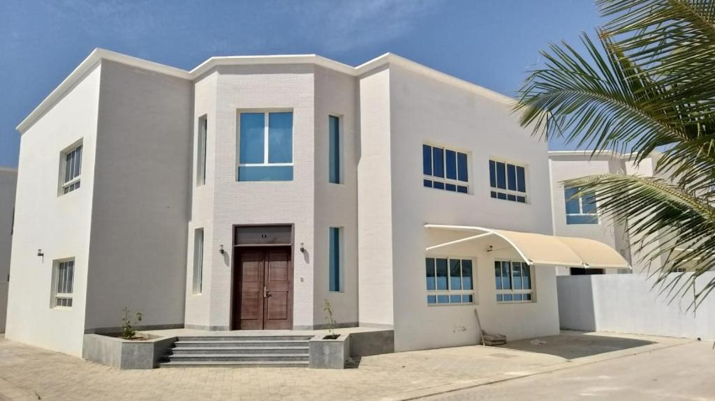 塞拉莱Luxury Garden Villas Complex的前面有棕榈树的白色房子