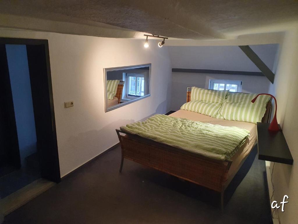 Wanfried"Bedroo" Ferienwohnung am historischen Hafen的一间小卧室,配有一张床和镜子