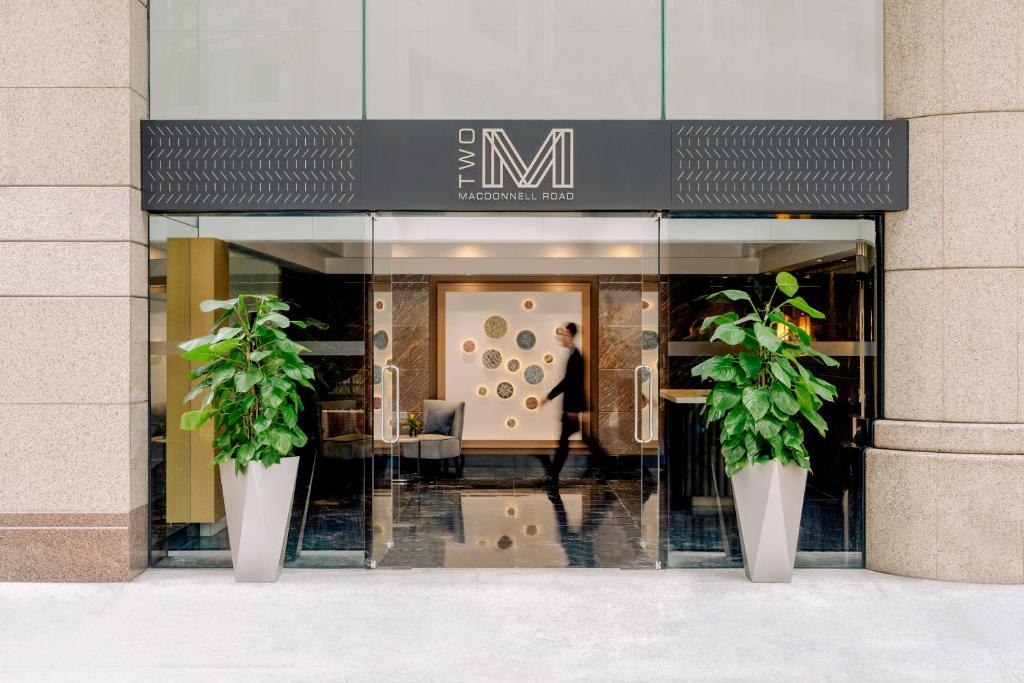香港麦当劳道贰号酒店式服务住宅公寓的前面有两株盆栽植物的商店