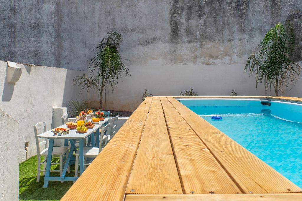 科尔萨诺Villa Franitu - Corsano的旁边设有桌子和糕点的游泳池