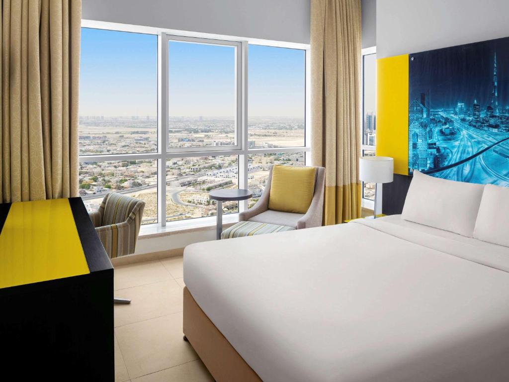 迪拜阿大吉奥高级迪拜阿尔巴沙公寓式酒店的酒店客房设有一张床和一个大窗户