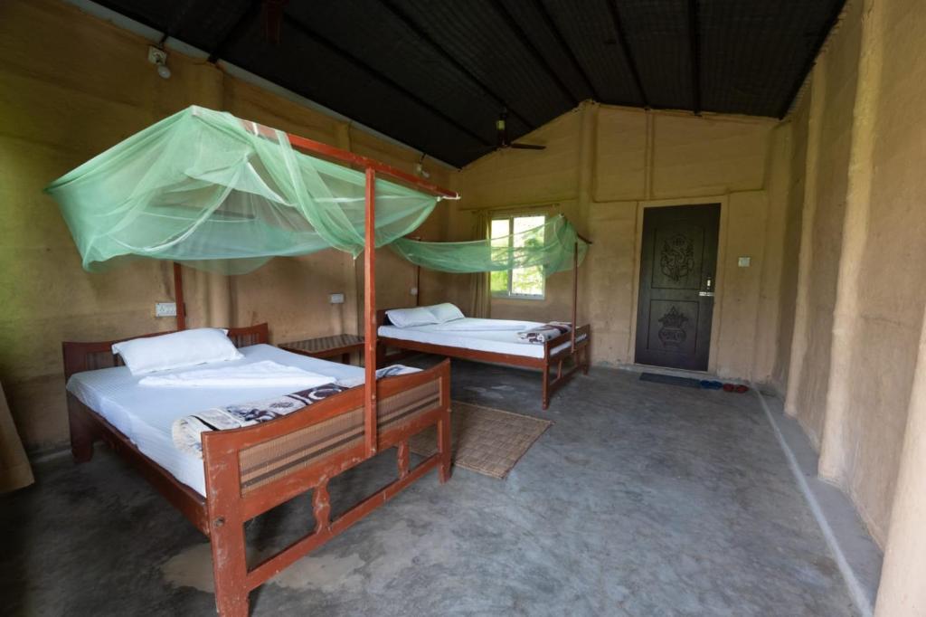 BhurkīāNamaste Bardiya Resort的一间设有两张床和一把遮阳伞的房间