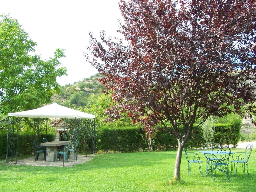 拉斯普纳Apartamentos Casa Esperanza - Ordesa的院子里的桌子和椅子以及雨伞