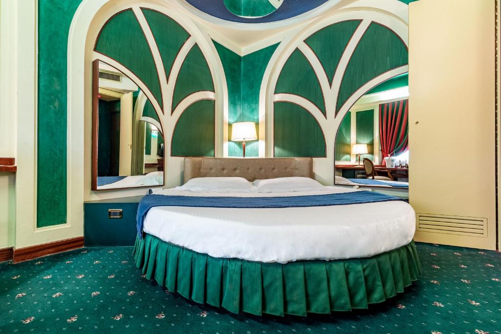利米托迪皮奥尔泰洛Hotel Motel Miami的一间卧室设有一张大床和绿色的墙壁