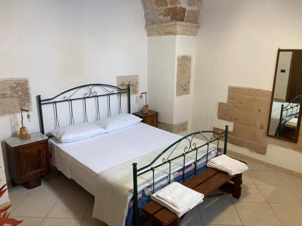 库特罗菲安诺Otium Salento的一间卧室配有一张床、一张桌子和一面镜子