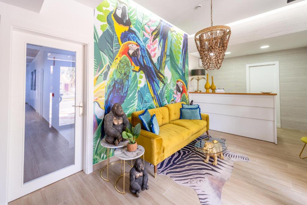 马拉加Hostal Romerito的客厅配有黄色沙发和色彩缤纷的绘画