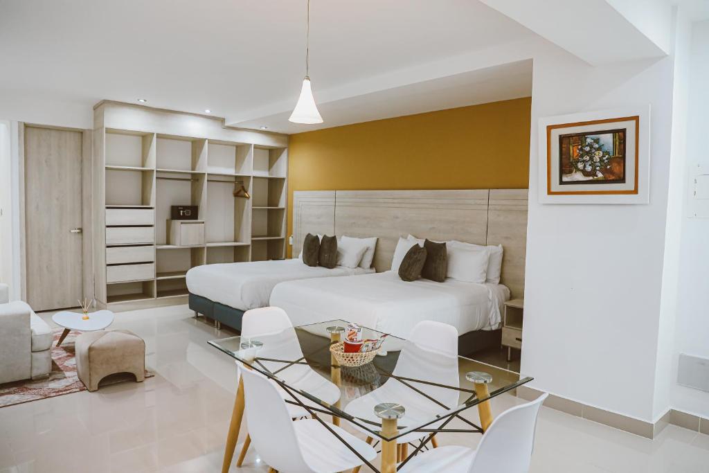 巴兰卡韦梅哈Hotel Súper Estrellas的酒店客房带两张床和一张桌子以及椅子。