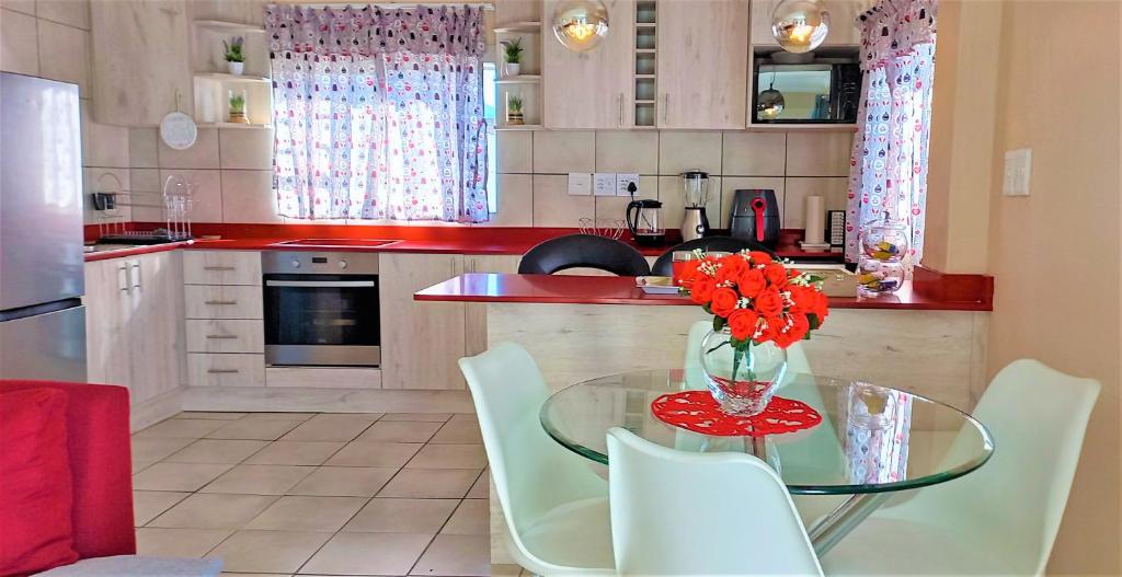 德班维尔Arlogenix的厨房配有带鲜花的玻璃桌