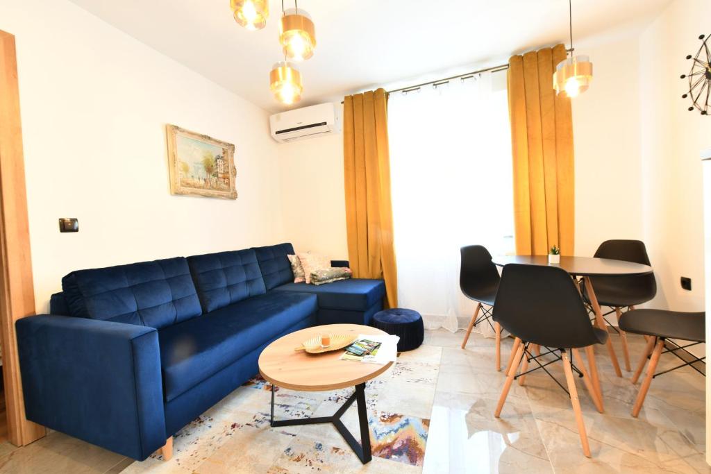 拉科维察Apartmani Brium的客厅配有蓝色的沙发和桌子