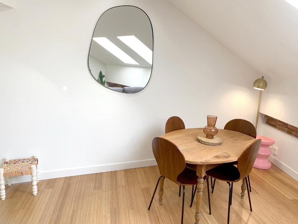 图卢兹Appartement au centre de Toulouse的一间带桌子和镜子的用餐室