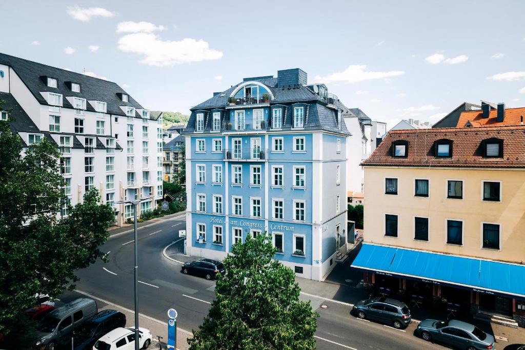 维尔茨堡DAS v EVERT Hotel - am Congress Centrum Würzburg的城市街道上的蓝色建筑,有建筑