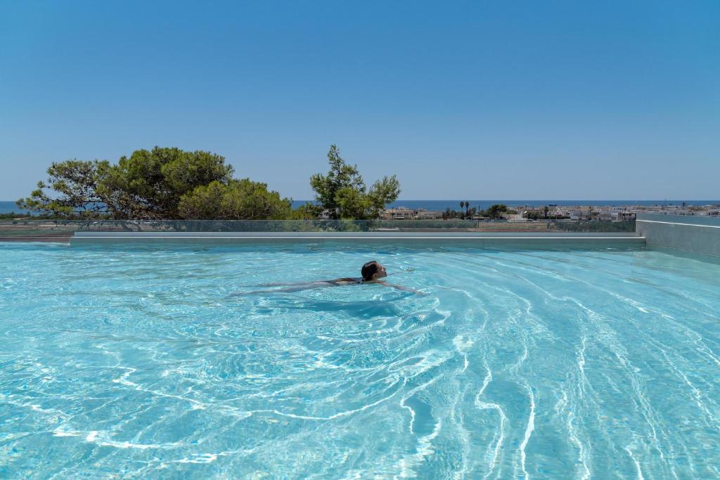 萨尔维Perla Saracena Hotel & Restaurant的在大型游泳池游泳的人