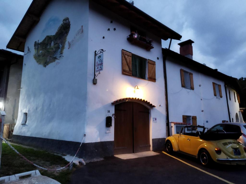 卢里西亚Il Ciliegio di Lurisia的停在白色建筑前面的黄色汽车