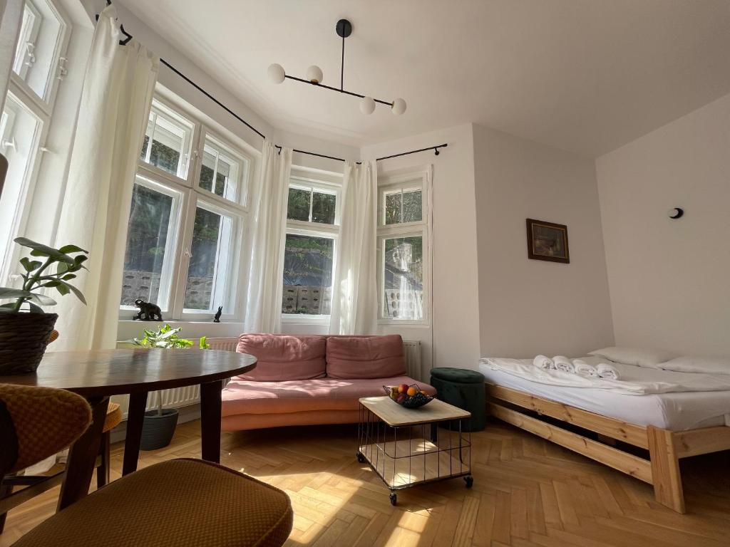 格但斯克wREST modern Apartments Gdańsk Wrzeszcz的客厅配有粉红色的沙发和桌子