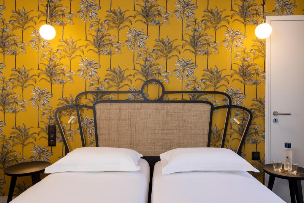 巴黎苏伊士酒店的黄色壁纸客房内的两张床