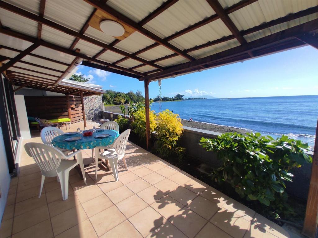 阿鲁埃TAHITI - Taharaa Beach Bungalow的一个带桌椅的庭院和大海