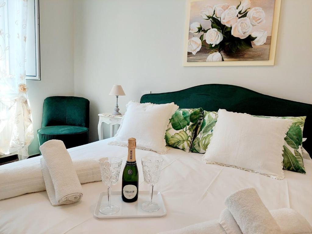 罗马BBHOME Saint Paul design boutique Apartment的床上有一瓶葡萄酒和眼镜