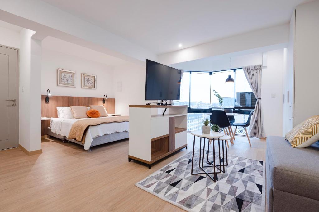 利马ALU Apartments - Miraflores f/Doubletree Hilton c/AC Wifi+60M的一间卧室配有一张床,并在一间客房内配有电视。