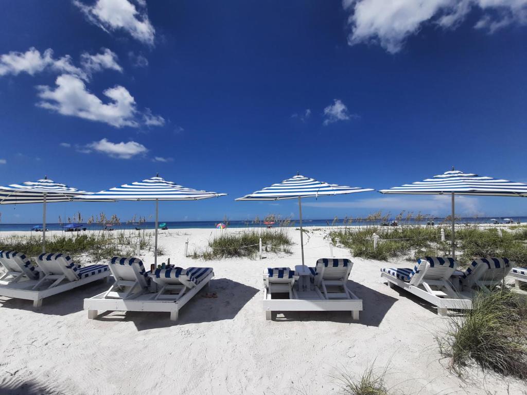 布雷登顿海滩Bungalow Beach Resort的海滩上的一组椅子和遮阳伞