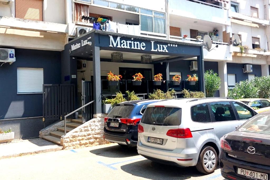 普拉Marine Lux apartments的两辆汽车停在一个马丁内斯线前