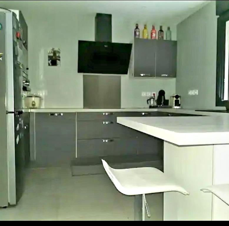 勒唐蓬Chambre privée dans maison的白色的厨房配有白色的柜台和冰箱。