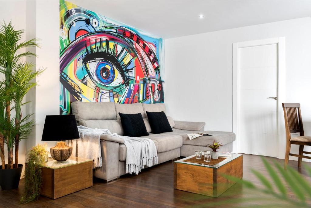 安度亚尔Viviendas con Fines Turísticos "Quivir Pidal"的客厅配有沙发和墙上的绘画