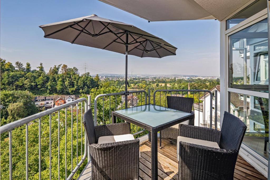法伦达尔Koblenz Rheinblick Appartement的阳台配有桌椅和遮阳伞。