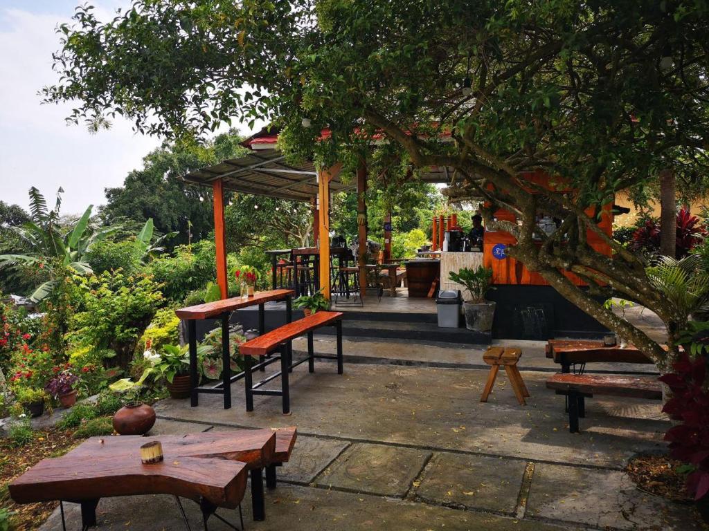 SapitBalelangga Bed & Breakfast的花园中的一组桌子和长椅