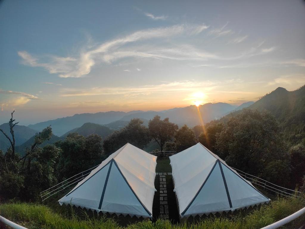 比姆塔尔DugDug Camps - Glamping Amidst Nature的山顶上的一个帐篷,享有日落美景
