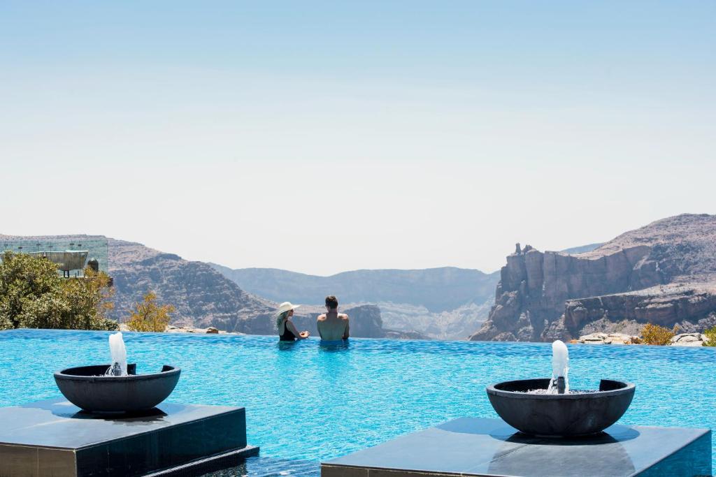 Al ‘Aqar绿山安纳塔拉度假酒店的两人坐在水塘里