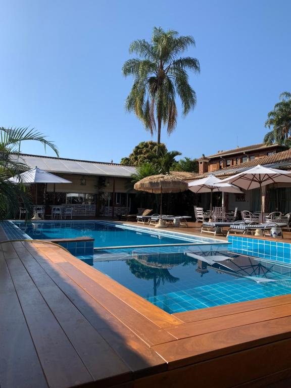 布罗塔斯Villa Maria Pousada de Charme的一个棕榈树背景的大型游泳池