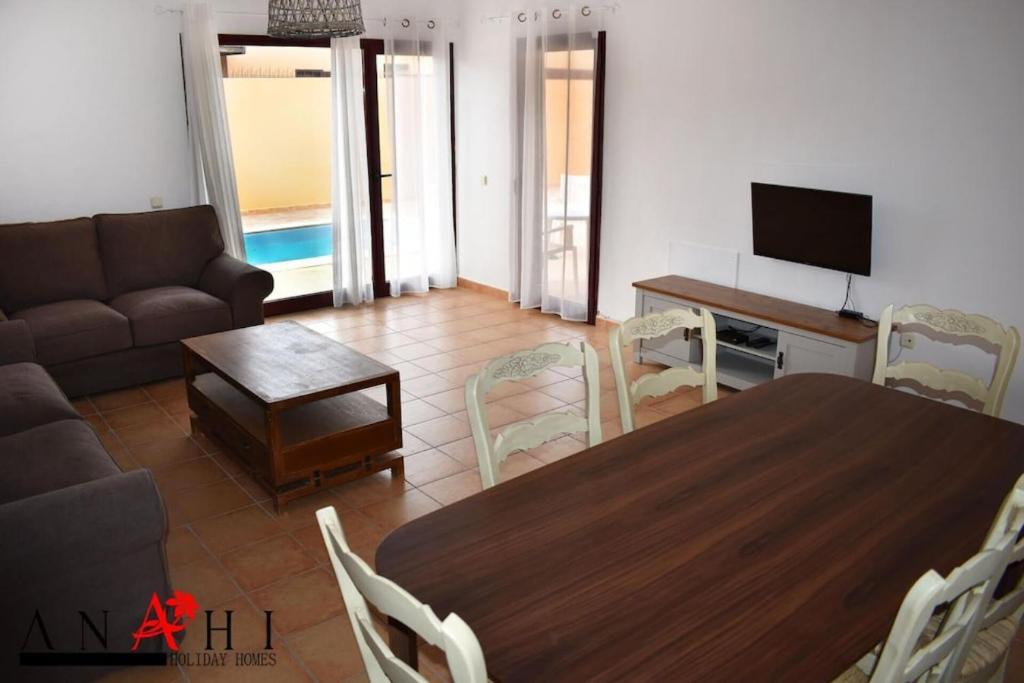 拉奥利瓦Anahi Home Corralejo - Villa Cardon 12的客厅配有桌子和沙发