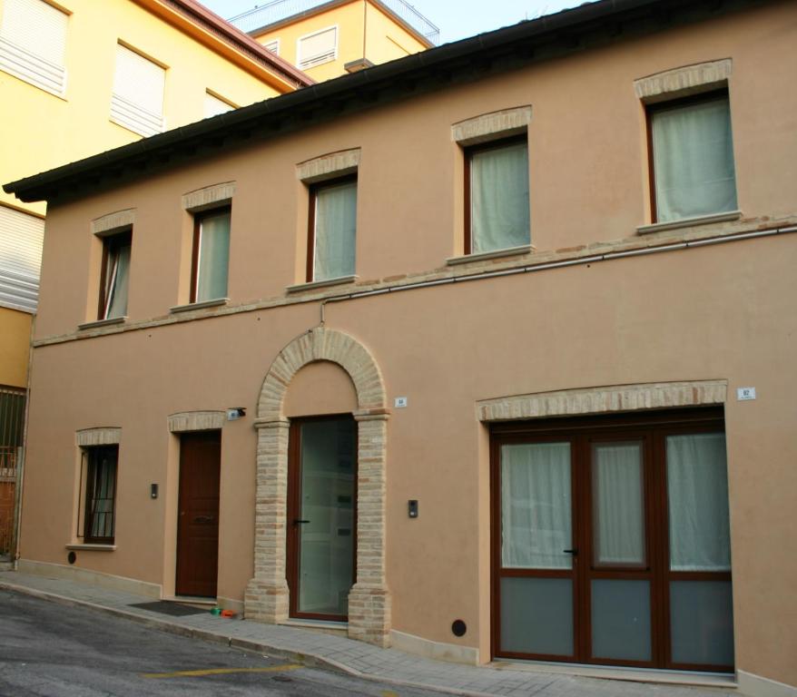 洛雷托A casa di Giò的一座带两个车库门和拱门的古老建筑