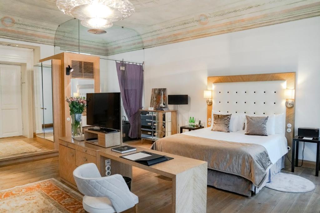 里加Dome Hotel的一间卧室配有一张床、一张书桌和一台电视。