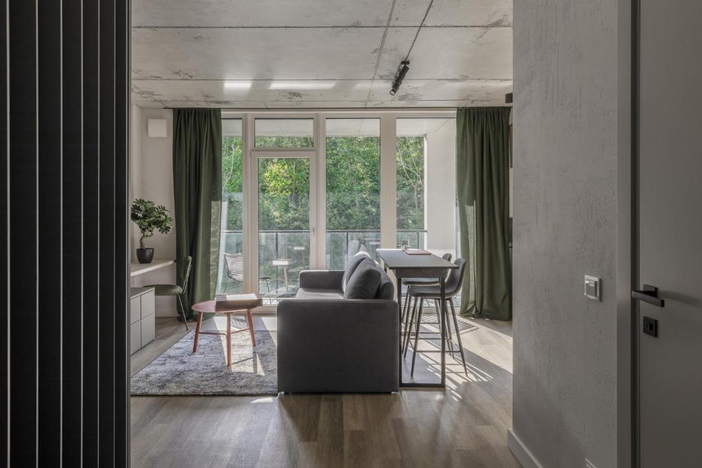 维尔纽斯Urban Jungle Apartments by Reside Baltic的客厅配有沙发和桌子