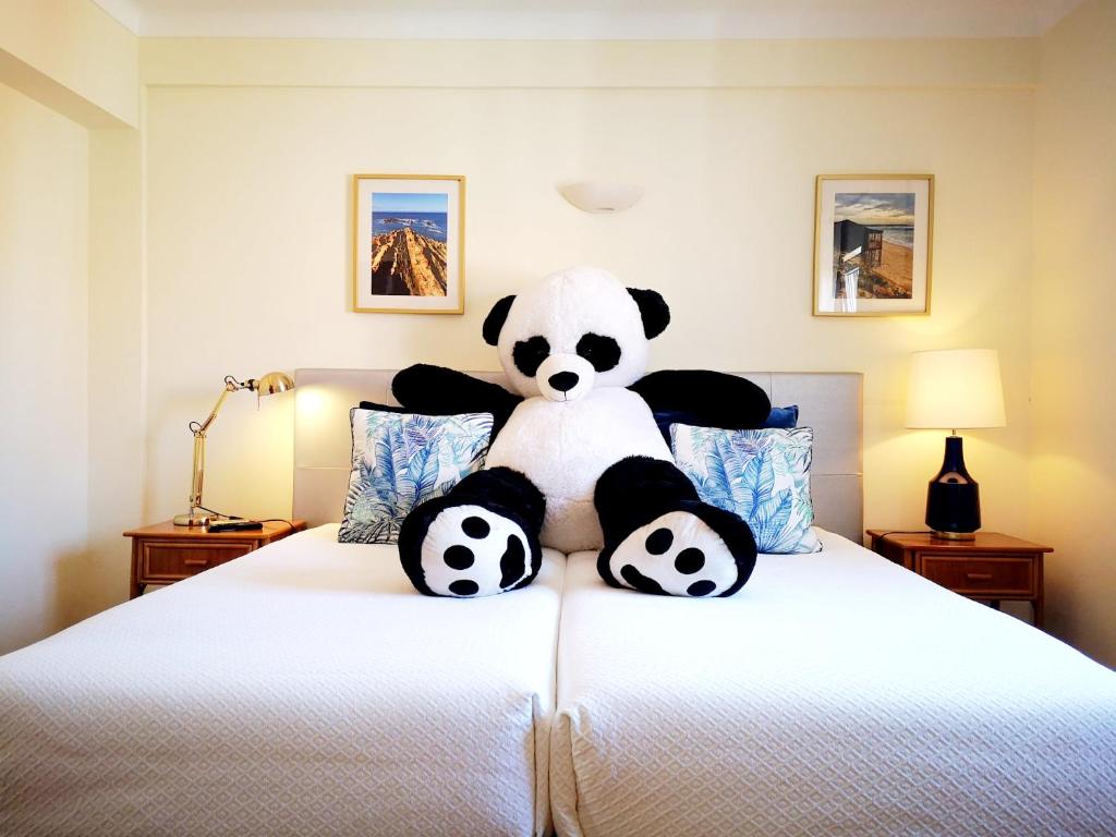 米尔芳提斯城The Blue Bamboo Hotel - Duna Parque Group的一只塞满食物的熊猫坐在床上