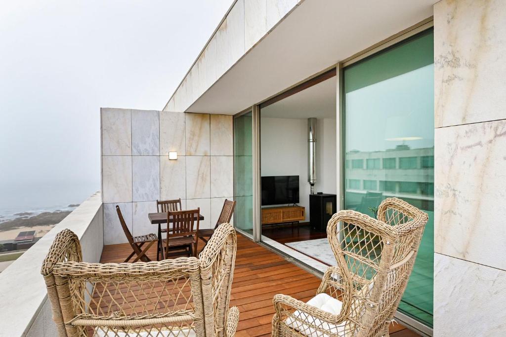莱萨·达·帕尔梅拉Leça Front Beach Luxury Penthouse的阳台配有桌椅和电视。