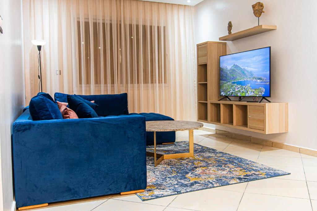 达赫拉Résidence Amal的客厅配有蓝色的沙发和电视