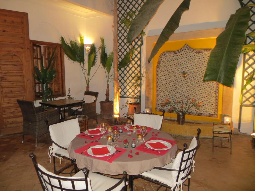 马拉喀什艾琳摩洛哥传统庭院旅馆的一间带红色桌布的餐桌的用餐室