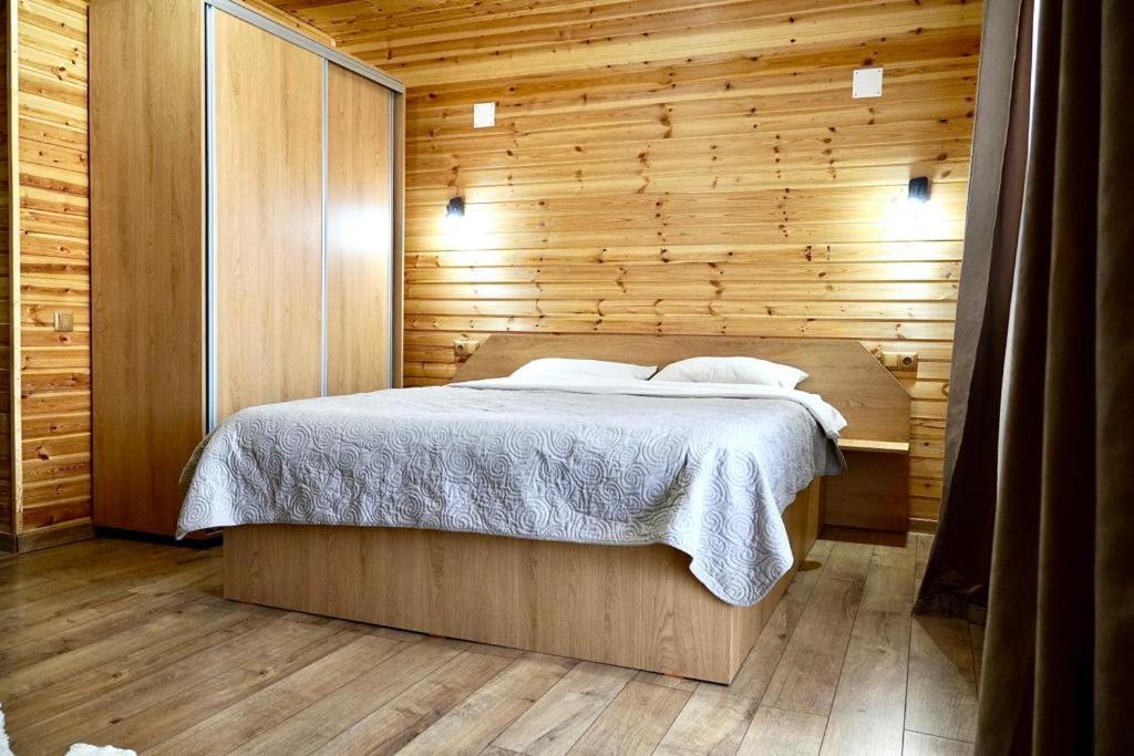 布拉索夫Casa Felice的卧室配有木墙内的一张床