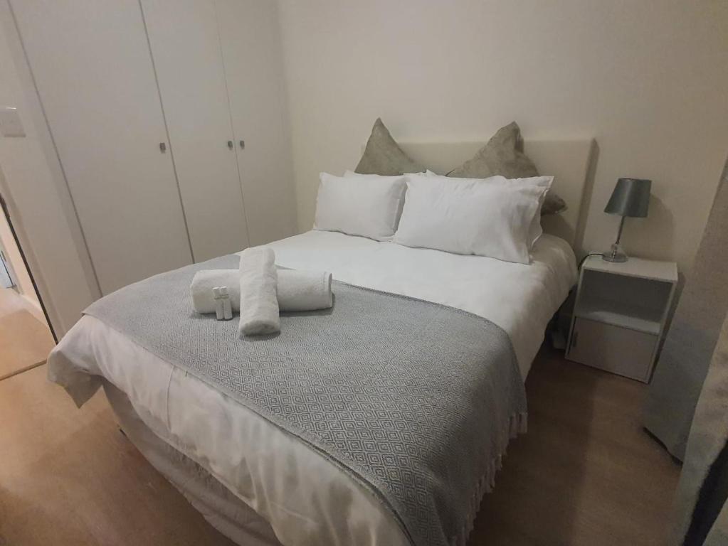 约翰内斯堡Stunning, Modern 1 bedroom Apartment Sandton的一间卧室配有一张大床和毛巾