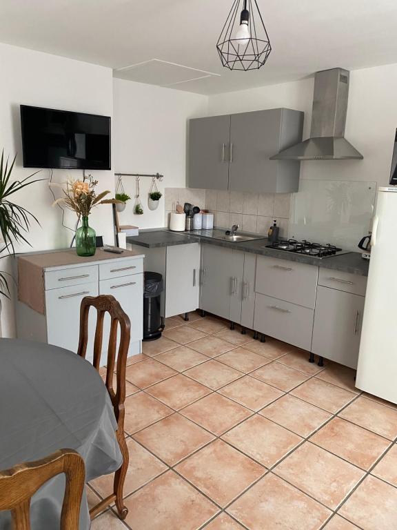 Maison calme et confortable的厨房配有白色橱柜和一张桌子