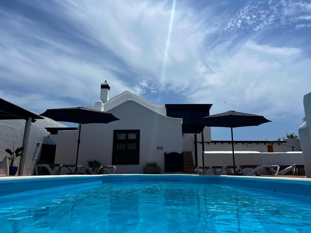 纳萨雷特Nazaret Villa with heated pool的房屋前的带遮阳伞的游泳池